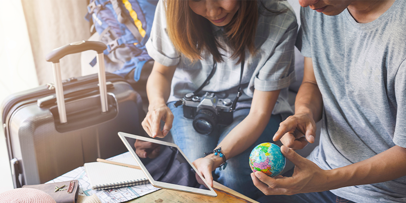 Young couple planning vacation trip and searching information or booking hotel on a smart phone