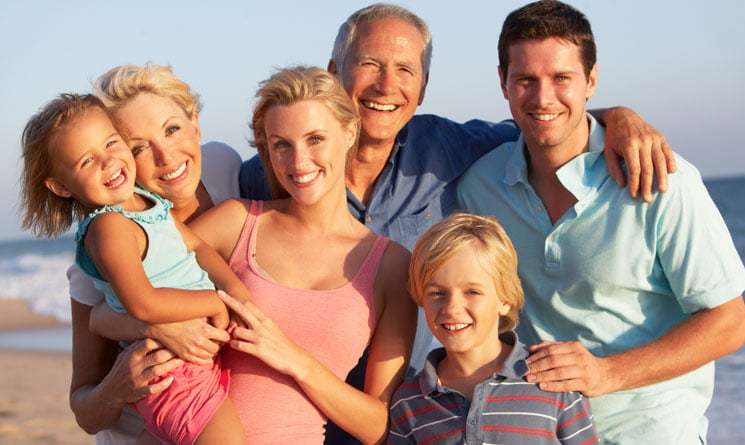 Multigenerational family posing for photo on beach
